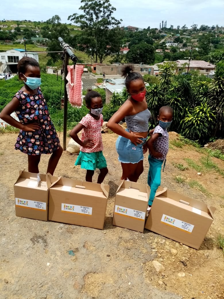 Children standing with donated Preppi's Bag of Love boxes