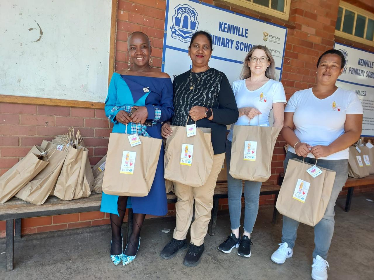 Bag of Love partners holding stationery packs at Kenville Primary School