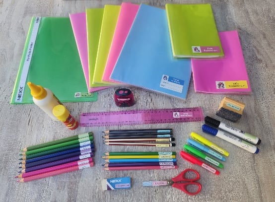 A labelled school stationery set with covered books, pencils and supplies