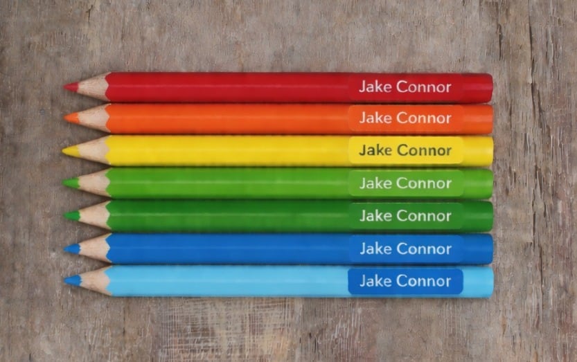 A set of coloured pencils individually labelled with a learner’s name